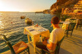 Dinner on a traditional tavern in Ammoudi Bay as the sun sets of Santorini