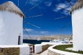 Looking through the picturesque windmills down to the chora and the Aegean Sea, Mykonos island