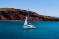 The catamaran sailing around the Santorinian coastline