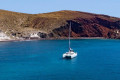 The catamaran sailing around the Santorinian coastline