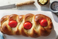 Easter bread or Tsoureki is usually decorated with red eggs