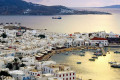 Mykonos island port during susnet, golden sea and white houses