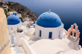 Blue-domed church in Oia overlooking the Santorinian caldera