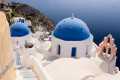 Blue-domed church in Oia as the serenity of the caldera below completes the picture