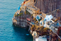 Houses perched on the volcanic cliffs by the sea in Oia town, Santorini island