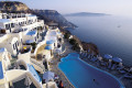 View of sugar cubed houses, pool and the infinite blue sea encircling the caldera, Santorini island