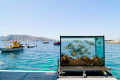 Aquarium backdropped by the turquoise waters of the port, Santorini island