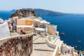 White concrete staircases leading down the volcanic cliffs to the blue sea, Santorini island