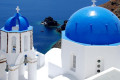 Blue-domed church with the Santorinian caldera in the background
