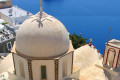 Church dome in Santorini with a view of the caldera below