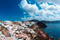 Amazing Santorini landscape and seascape with colorful houses perched on volcanic cliffs above the vast blue sea