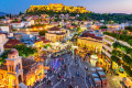 Acropolis and the Monastiraki Square illuminating the sky of downtown Athens at dusk