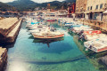 Small port in Hydra with fishing boats gently rocked by the waves