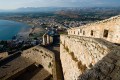 The imposing walls of castle Palamidi, in background the bay and the village of Nafplion city, Greece