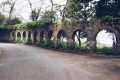 Stone arcade wall with monastery behind in Mon Repos park