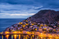 The main town of Hydra lights up at night and sparkles against the serene sea