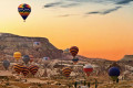 Sunset in Cappadocia with air balloons rising to enjoy the view