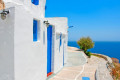 Picturesque alley next to traditional island houses backdropped by the blue sea, Sifnos island