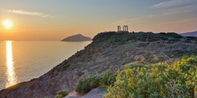 Temple of Poseidon at the edge of Cape Sounion overlooking the Aegean Sea at sunset, Attica region