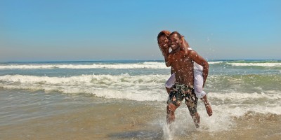 Happy couple splashing by the sea