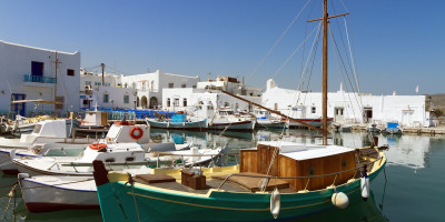Traditional Greek boats and white houses at Parikia port, Paros island