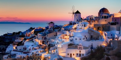 Traditional houses and windmill by night, Santorini island sunset