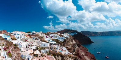 Panoramic view of sugar cubed houses perched on the volcanic cliffs of the caldera, Santorini island