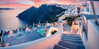The sky is pink as the sun sets in Fira, Santorini