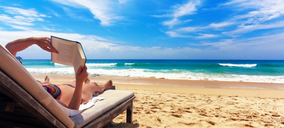 Woman relaxing and reading a book by the sea Woman relaxing and reading a book by the sea