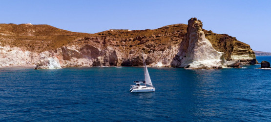 The catamaran sailing around the Santorinian coastline