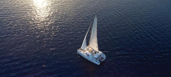 The catamaran sailing during sunset