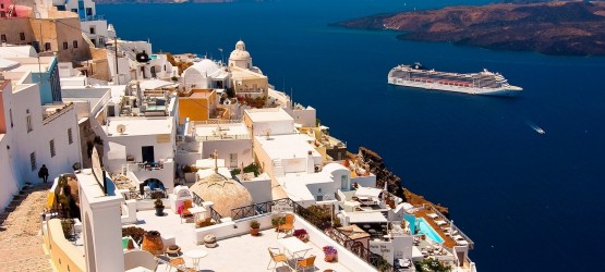 View of candy colored houses perched on the volcanic cliffs of the caldera, Santorini island