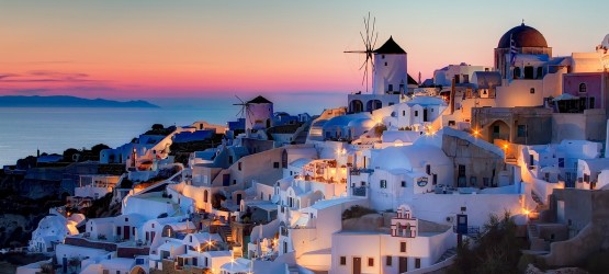 Traditional houses and windmill by night, Santorini island sunset