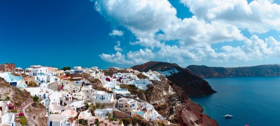 Panoramic view of sugar cubed houses perched on the volcanic cliffs of the caldera, Santorini island