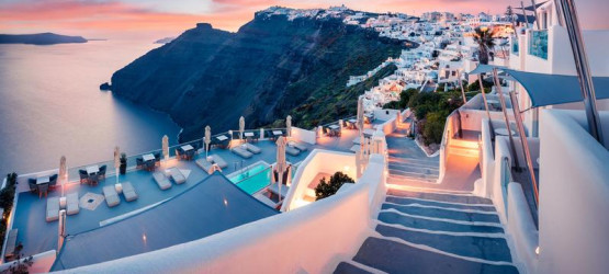 The sky is pink as the sun sets in Fira, Santorini